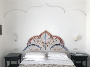 a bed with an ornate headboard in a bedroom at Palazzo Marzoli charme Resort - Small Luxury Hotel in Positano