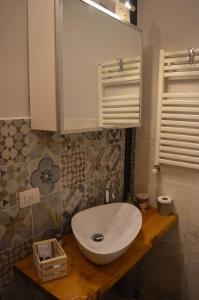 een badkamer met een witte wastafel op een houten aanrecht bij Il loft di Nina in Florence +7 foto's