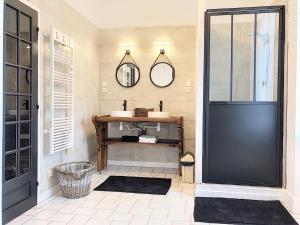 a bathroom with a black door and a mirror at la Porte aux Dames in Romorantin