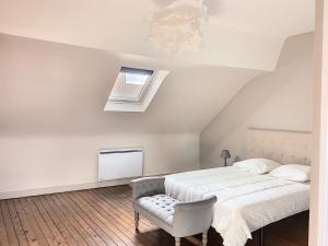 a bedroom with a bed and a window and a chair at la Porte aux Dames in Romorantin