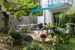 a patio with tables and chairs in a garden at Gästehaus Moser in Weil am Rhein