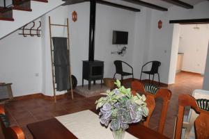 - un salon avec une table et une cheminée dans l'établissement CASA RURAL EL ARRIERO, à Zahara de la Sierra