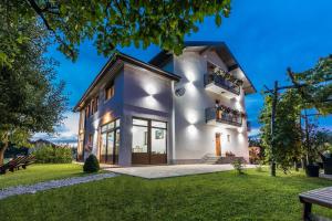 una casa blanca con un patio verde en Apartments Lucić, en Slunj