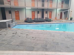 a large swimming pool in a building with chairs at Green Side accommodation in Rustenburg