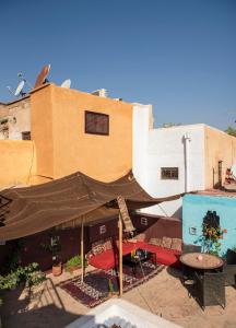 un patio con una mesa y una sombrilla marrón en Dar anne, en Fez