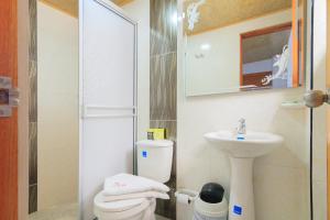 a small bathroom with a toilet and a sink at Hotel El Rubí in Bucaramanga