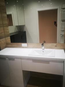 y baño con lavabo blanco y espejo. en Apartament Przy Galerii en Radom