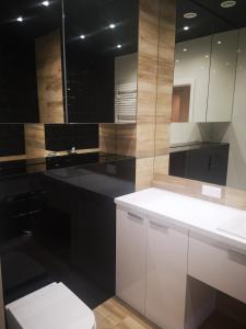 baño con armarios en blanco y negro y aseo en Apartament Przy Galerii en Radom