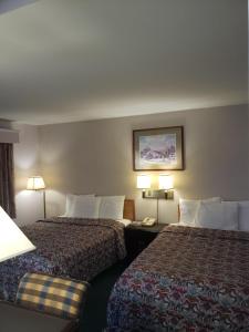 a hotel room with two beds and two lamps at Budget Inn Horseheads in Horseheads