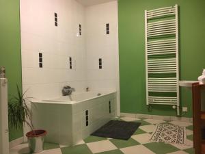 baño verde y blanco con bañera y lavamanos en Emel b&b, en Laville-aux-Bois