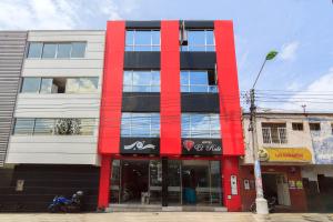 ein rotes und schwarzes Gebäude mit einem Motorrad, das vorne parkt in der Unterkunft Hotel El Rubí in Bucaramanga