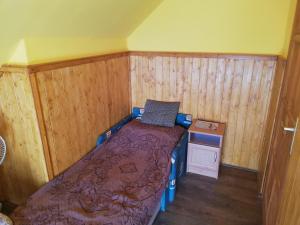 een klein bed in een kamer met houten wanden bij Apartment in Balatonszemes 38456 in Balatonszemes