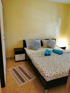 una camera da letto con un letto e pantofole blu di Apartments Ivan a Vir (Puntadura)