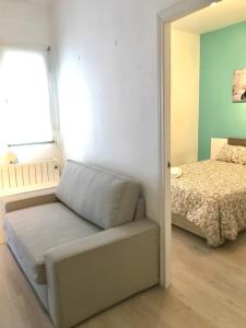 a bedroom with a bed and a couch and a window at Centro Madrid Rio - Monederos C in Madrid