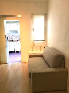 a room with a couch and a window and a kitchen at Centro Madrid Rio - Monederos C in Madrid