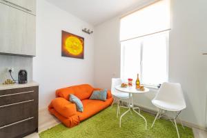 pomarańczowe krzesło w pokoju ze stołem w obiekcie Apartament Copernicus Olsztyn w Olsztynie