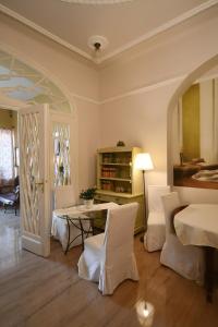 - un salon avec une table et des chaises blanches dans l'établissement Tulipán Villa Panzió, à Szolnok