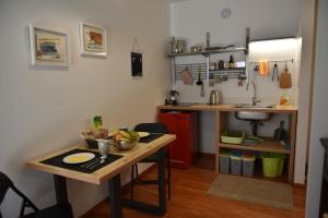 uma pequena cozinha com uma mesa e um lavatório em B&B DEL VIAGGIATORE em Rovereto