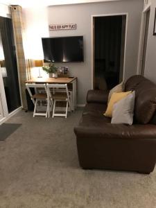 a living room with a couch and a desk with a television at Appley Lodge Glan Gwna in Caernarfon