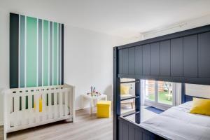sypialnia z łóżkiem piętrowym i łóżeczkiem dziecięcym w obiekcie La Serrisienne 2 - Val d'Europe - Disneyland Paris - 4 à 7 Personnes w mieście Serris