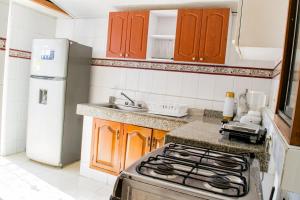 a small kitchen with a stove and a refrigerator at Hotel Ocean View in Cartagena de Indias