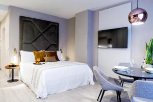 a bedroom with a large bed and a dining room at Voghe Premium Flats in Valencia