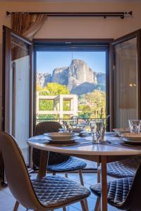 a table and chairs with a view of the mountains at Harmony in Kalabaka