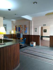 a lobby of a hospital with a bar and a television at Sollarium GINI Suítes in Guarapari