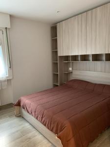 um quarto com uma cama grande e armários de madeira em Casa Chiara Andalo Centro em Andalo