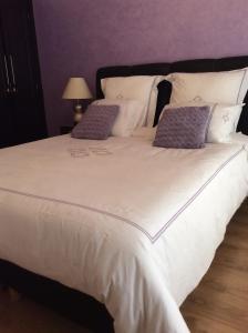 un grande letto bianco con due cuscini sopra di Appartement de luxe a Casablanca