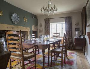 a dining room with a wooden table and chairs at Forthay Bed and Breakfast in North Nibley
