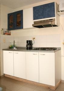 a kitchen with white cabinets and a stove at Aloha in Bogotá