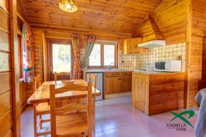 a kitchen with wooden cabinets and a table in a cabin at Xixerella Park Bungalows in Xixerella