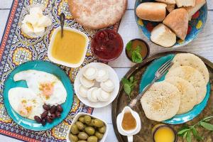 a table topped with plates of eggs and bread at Sultan Luxury Camp in Merzouga +51 photos