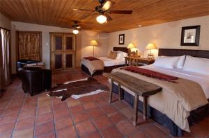 a large bedroom with two beds and a table at The Maverick Inn in Alpine