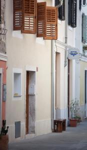 a building with wooden shutters on the side of it at Little house - Hiška in Izola