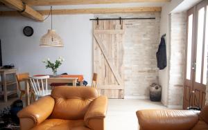 ein Wohnzimmer mit Sofa und Scheunentür in der Unterkunft Little house - Hiška in Izola