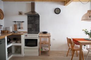 a kitchen with a stove top oven next to a table at Little house - Hiška in Izola