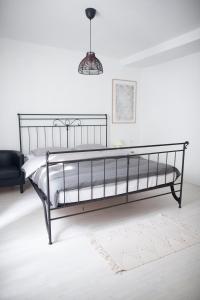 una cama de metal negro en una habitación blanca en Little house - Hiška en Izola