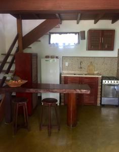 eine Küche mit einem großen Holztisch und Stühlen in der Unterkunft Vila Sofia chalès in Morro de São Paulo