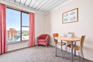 een kamer met een tafel en stoelen en een raam bij Balmoral On York in Launceston