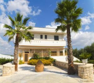 a house with two palm trees in front of it at Residence Contrada Schite in Presicce