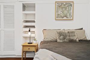 um quarto com uma cama e uma mesa com um candeeiro em Hideaway on Keats - Keats Street, Byron Bay em Byron Bay