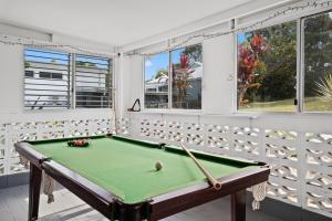 a pool table in a room with windows at Hideaway on Keats - Keats Street, Byron Bay in Byron Bay