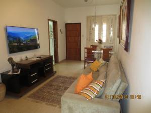 sala de estar con sofá y TV de pantalla plana en Constante Ramos com Wifi, en Río de Janeiro