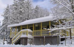 a yellow house with snow on top of it at Fivespot Cabin in Pinehurst
