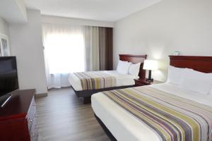 een hotelkamer met 2 bedden en een flatscreen-tv bij Country Inn & Suites by Radisson, Biloxi-Ocean Springs, MS in Ocean Springs