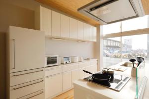 a kitchen with white cabinets and a counter top at 渚泊魚津丸 in Motoshin