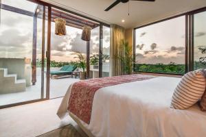 Copal Tulum Hotel في تولوم: غرفة نوم مع سرير وإطلالة على المحيط