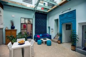 Dar anne في فاس: غرفة معيشة مع جدران زرقاء وأريكة زرقاء